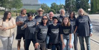 Group photo of program coordinator and Science 101 students smiling while wearing matching dark grey UBC tshirts